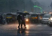 Delhi-NCR Weather Update: IMD Issues Orange Alert for Intense Evening Showers Traffic headlights reflecting on a rain-slicked urban highway in New Delhi under heavy, dark evening storm clouds.